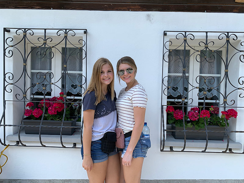 Girls in front of old style Swiss home