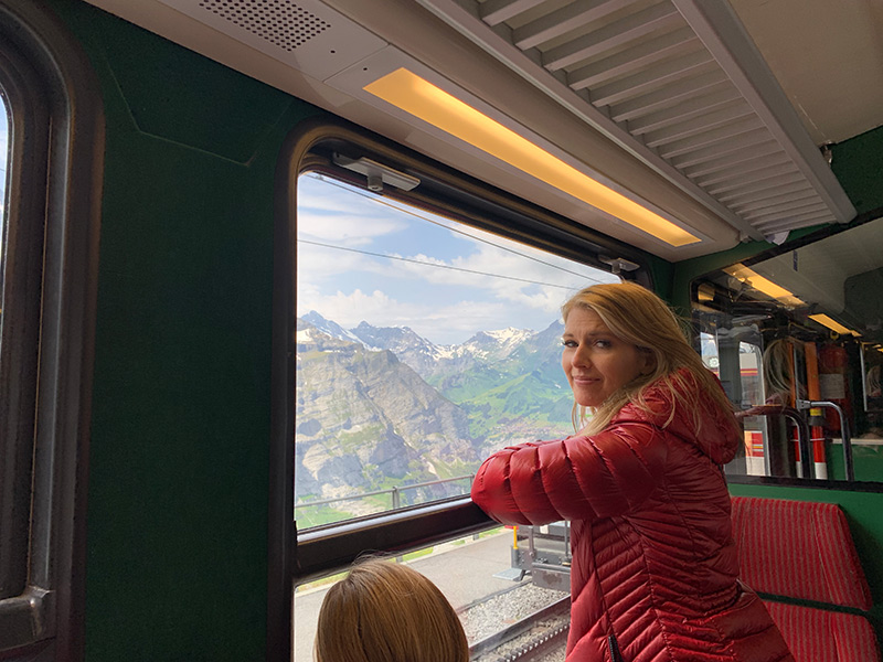 Woman looks out window of Jungfrau Train in Switzerland