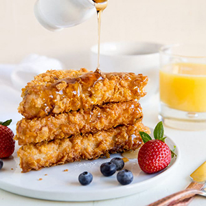 Cornflake crusted french toast with syrup on it
