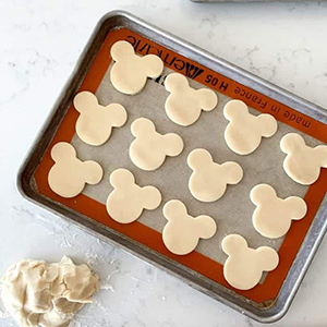 mickey mouse themed sugar cookies on a cookie sheet