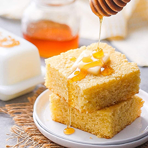 Sweet cornbread with honey drizzled over it